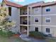 Three-story condo building featuring a spanish tile roof, beige exterior, and private balconies at 3016 Parkway Blvd # 110, Kissimmee, FL 34747