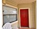 Close-up of the red front door with visible unit number and a nearby window for natural light at 3016 Parkway Blvd # 110, Kissimmee, FL 34747