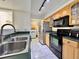 Well-lit kitchen with stainless steel appliances, tile flooring, green countertops and laundry access at 3016 Parkway Blvd # 110, Kissimmee, FL 34747