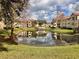 Scenic view of the community pond surrounded by well-maintained landscaping and residential buildings at 3016 Parkway Blvd # 110, Kissimmee, FL 34747