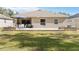 Backyard featuring a patio with dining set, fire pit, and well-maintained lawn at 34429 Alameda Dr, Sorrento, FL 32776
