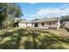 A view of the home's backyard, with a lawn, patio, dining set, and fire pit at 34429 Alameda Dr, Sorrento, FL 32776
