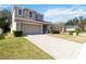 Charming two-story home with well-manicured lawn and a long brick driveway at 34429 Alameda Dr, Sorrento, FL 32776
