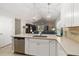 Open kitchen with stainless steel appliances, large island with bar seating, and modern lighting fixtures at 34429 Alameda Dr, Sorrento, FL 32776