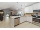 Bright kitchen features white cabinets, stainless steel appliances, and a breakfast bar overlooking the open living space at 34429 Alameda Dr, Sorrento, FL 32776