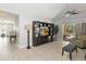 Spacious living room with tile flooring, entertainment center, ceiling fan, and sliding glass doors leading to the outdoor area at 34429 Alameda Dr, Sorrento, FL 32776