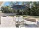 View of the patio, with a dining set, stone wall, and backyard at 34429 Alameda Dr, Sorrento, FL 32776