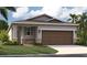 Charming one-story home featuring stone accents, a two-car garage, and a well-manicured lawn at 3495 Salvia Ct, Tavares, FL 32778