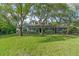 Inviting two-story home with blue siding, well-manicured lawn, mature trees, and a charming front porch at 3860 Branton Dr, Oviedo, FL 32765