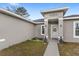 Inviting front entrance of a home featuring decorative pillars and a well-maintained lawn at 42 Willow Ln, Poinciana, FL 34759