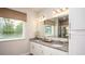 Bathroom featuring double sinks, granite countertops and a view of a lush outdoor landscape at 421 W Ariel Rd, Edgewater, FL 32141