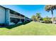 Condominium building featuring a large manicured lawn, balconies, and lush tropical landscaping at 4759 S Texas Ave # 4759C, Orlando, FL 32839