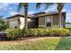 Elegant single-story home featuring manicured shrubbery and a spacious two-car garage at 569 Vista Sol Dr, Davenport, FL 33837