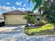 Beautiful single-story home featuring a well-manicured lawn, two car garage and lush landscaping at 569 Vista Sol Dr, Davenport, FL 33837