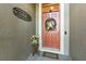 Welcoming front door with a charming wreath, flowers, and stylish welcome sign at 569 Vista Sol Dr, Davenport, FL 33837