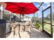 Inviting screened patio with dining area under a red umbrella and access to the spa at 569 Vista Sol Dr, Davenport, FL 33837