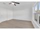 Minimalist bedroom showcasing wood floors, a ceiling fan, and a view from the window at 658 Black Eagle Dr, Groveland, FL 34736