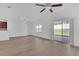 Bright living room with wood floors, a ceiling fan, and sliding glass doors leading to an outdoor patio at 658 Black Eagle Dr, Groveland, FL 34736