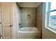 Modern bathroom with a tub, tiled shower, and a window offering natural light at 674 Creeping Fig St, Apopka, FL 32703