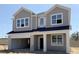 New two-story home features a gray exterior, welcoming front porch, and an attached two-car garage at 726 Pointe Emerson Blvd, Apopka, FL 32703