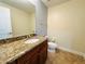 Half bath featuring granite countertops, a mirror, and toilet at 101 S Eola Dr # 1009, Orlando, FL 32801