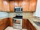 Kitchen showcasing stainless steel appliances, wooden cabinets, and granite countertops at 101 S Eola Dr # 1009, Orlando, FL 32801