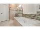 Bathroom featuring a soaking tub, tile backsplash, glass shower and a single sink vanity with white shutters at 10384 Se 41St Ter, Belleview, FL 34420