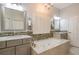 Bright bathroom featuring a soaking tub, tile backsplash, dual sink vanities, and white shutters at 10384 Se 41St Ter, Belleview, FL 34420