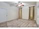 Neutral bedroom with a ceiling fan, tan carpet, white trim, and two windows with long fabric curtains at 10384 Se 41St Ter, Belleview, FL 34420