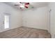 Bright bedroom with a ceiling fan, neutral carpet, white trim, and a door to the outside at 10384 Se 41St Ter, Belleview, FL 34420