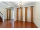 Elegant dining room featuring hardwood floors, chandelier, and decorative curtains at 10384 Se 41St Ter, Belleview, FL 34420