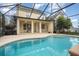 Inviting pool with screened enclosure and covered patio area at 10384 Se 41St Ter, Belleview, FL 34420