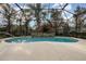 Screened-in pool area with stone accent wall and lush landscaping at 10384 Se 41St Ter, Belleview, FL 34420