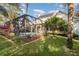 Backyard view featuring a screened-in pool, manicured landscaping, and solar panels at 10384 Se 41St Ter, Belleview, FL 34420