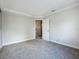 Bright bedroom with neutral carpet and walls, a window, and an open door showing stairs beyond at 1040 Waverly Dr, Longwood, FL 32750