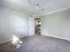 A brightly lit bedroom featuring neutral walls, carpet, and a view of a staircase through the doorway at 1040 Waverly Dr, Longwood, FL 32750