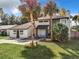 Charming two-story home with a well-manicured lawn and tropical landscaping with mature palm trees at 1040 Waverly Dr, Longwood, FL 32750