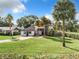 Inviting two-story home with manicured lawn and mature palm trees creating a serene tropical atmosphere at 1040 Waverly Dr, Longwood, FL 32750