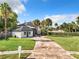 Charming two-story home with lush lawn, palm trees, and curved driveway leading to a spacious front yard at 1040 Waverly Dr, Longwood, FL 32750