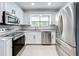 Modern kitchen with stainless steel appliances, white cabinetry and quartz countertops at 1040 Waverly Dr, Longwood, FL 32750