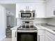 Modern kitchen featuring stainless steel appliances, white cabinetry, and grey countertops at 1040 Waverly Dr, Longwood, FL 32750