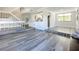 Sunlit living room offers gray wood-look flooring adjacent to the kitchen and staircase at 1040 Waverly Dr, Longwood, FL 32750