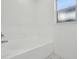 A clean and simple bathtub with white tiles and marble flooring at 11136 Einbender Rd, Orlando, FL 32825