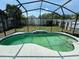 View of the screened-in outdoor pool with a concrete pool deck and grassy backyard at 11136 Einbender Rd, Orlando, FL 32825