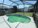 View of the screened-in outdoor pool with a concrete pool deck and grassy backyard at 11136 Einbender Rd, Orlando, FL 32825
