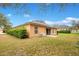 View of the home's backyard featuring a small patio and a neatly maintained lawn surrounded by lush greenery at 114 Alexandria Cir, Deland, FL 32724