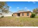 Image showcasing the home's backyard with a concrete patio, sliding glass doors, and a well-kept lawn at 114 Alexandria Cir, Deland, FL 32724