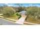 Aerial front view of a single-Gathering home with a well-manicured lawn and mature trees at 114 Alexandria Cir, Deland, FL 32724