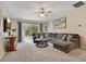 Comfortable living room featuring a plush gray sofa, large window, and neutral-toned walls at 114 Alexandria Cir, Deland, FL 32724