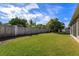 A well-manicured backyard featuring green grass and a wooden fence at 11554 Blackmoor Dr, Orlando, FL 32837